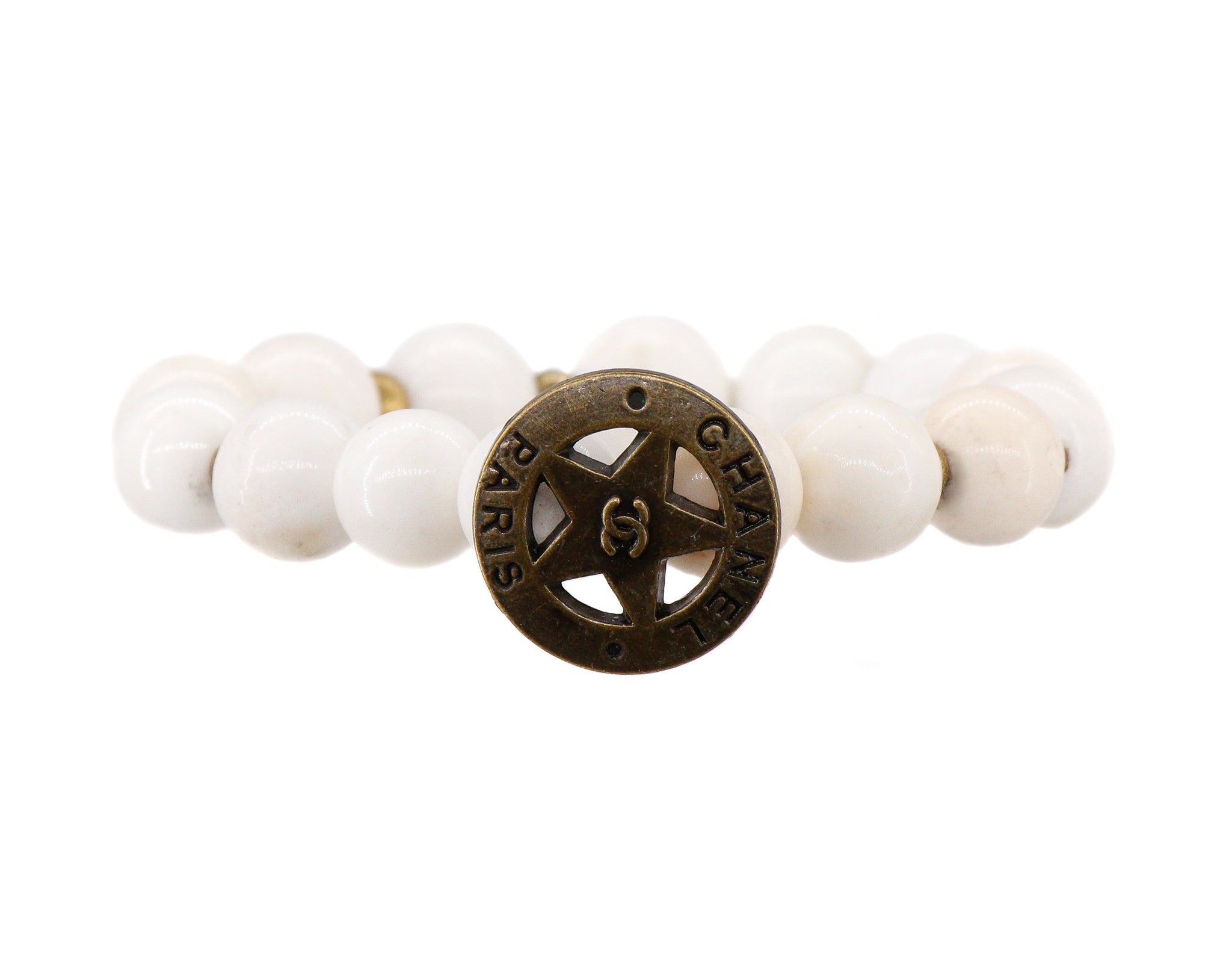 White conch bracelet with a repurposed designer brass button